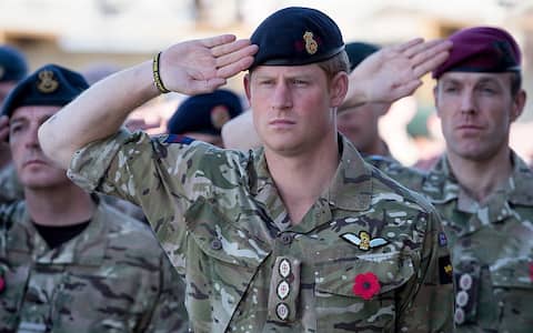 KANDAHAR, AFGHANISTAN - NOVEMBER 09:  Prince Harry salutes as the Last Post is played as he joins British troops and service personal remaining in Afghanistan and also International Security Assistance Force (ISAF) personnel and civilians as they gather for a Remembrance Sunday service at Kandahar Airfield November 9, 2014 in Kandahar, Afghanistan. As the UK combat mission in Afghanistan draws to an end in 2014 this year, which also marks the 100th anniversary of the start of World War One, 70 years since the D-Day landings will be the last time British service personal will gather in any great numbers in the south of the country.  (Photo by Matt Cardy/Getty Images)