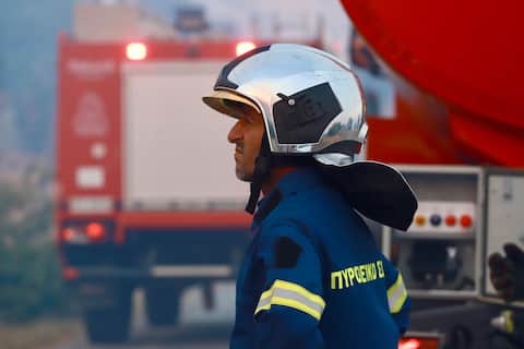 epa13140352 A firefighter works to extinguish a fire in low vegetation near Krya Vrysi, Rethymno, Crete, Greece, 29 July 2026. More than 150 firefighters, supported by four helicopters and four firefighting aircraft, were deployed to tackle the blaze. Two firefighters died while battling the fire, according to the Greek Fire Service.  EPA/NIKOS CHALKIADAKIS