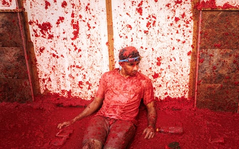 epa13192447 A man takes part in the battle with overripe tomatoes during the traditional 'Tomatina' fiesta in Bunol, Valencia, Spain, 26 August 2026. Thousands of people attend the annual event, where overripe tomatoes are thrown during the traditional tomato fight.  EPA/BIEL ALINO