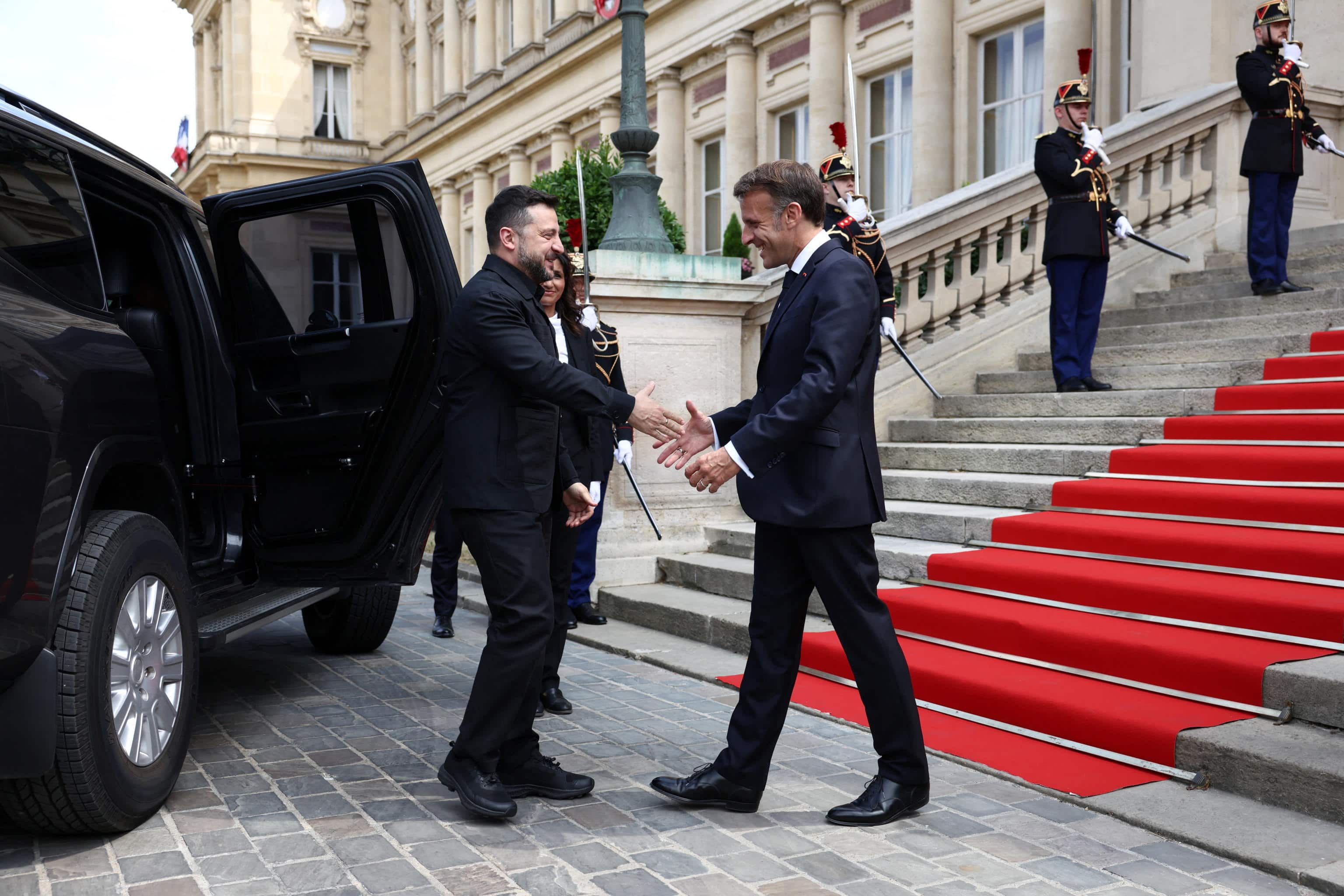 epa13108474 French President Emmanuel Macron (R) shakes hands with Ukrainian President Volodymyr Zelensky (L) as he arrives for an Integrated Anti-Ballistic Missile Coalition meeting at the Quai d'Orsay in Paris, before a meeting with countries involved in the 'Coalition of the Willing' supporting Ukraine, on the eve of Bastille Day celebrations, France, 13 July 2026.  EPA/Tom Nicholson / POOL  MAXPPP OUT