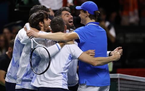 Italy's Jannik Sinner (R) celebrates his victory with teammates after beating Netherlands' Tallon Griekspoor during their final singles match between Italy and Netherlands at the Davis Cup Finals at the Palacio de Deportes Jose Maria Martin Carpena arena in Malaga, southern Spain, on November 24, 2024. (Photo by Thomas COEX / AFP) (Photo by THOMAS COEX/AFP via Getty Images)