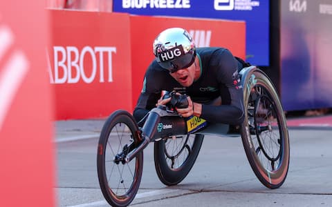 CHICAGO, ILLINOIS - OCTOBER 11: Men’s wheelchair champion Marcel Hug celebrates after he crosses the finish line at the Chicago Marathon on October 11, 2026 in Chicago, Illinois. (Photo by Isaac Wasserman/Getty Images)