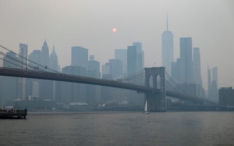 epa13116413 Wildfire smoke is seen amongst the Manhattan skyline and Brooklyn Bridge from the Brooklyn Promenade in the Brooklyn borough of New York, New York, USA, 16 July 2026. The National Weather Service has issued an Air Quality Alert until the end of the day on 16 July in New York due to smoke from wildfires in Canada affecting air quality in several US states.  EPA/CHRISTOPHER NEUNDORF