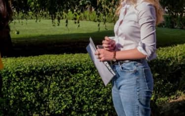 studentessa davanti a una siepe