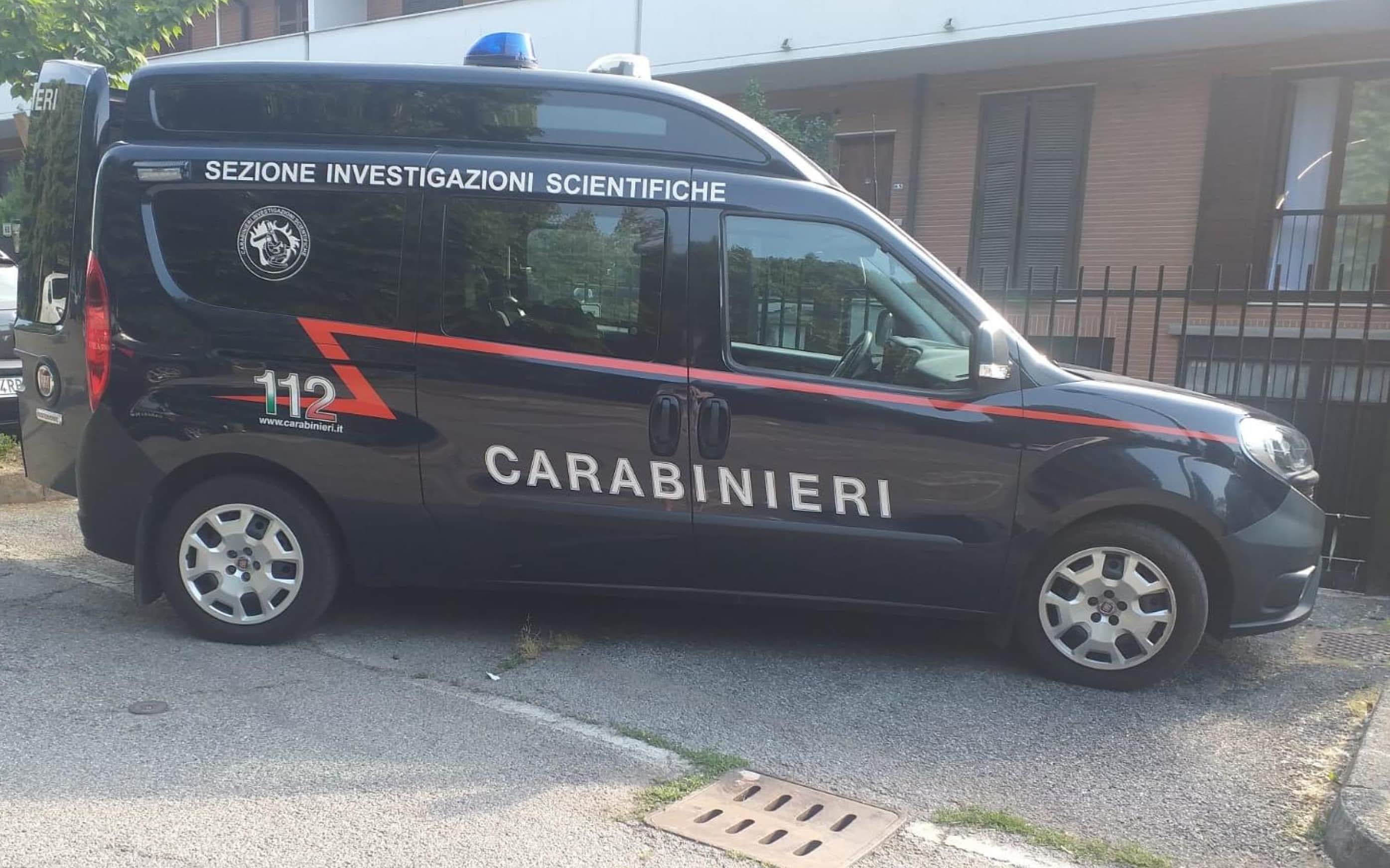 I carabinieri all'esterno della palazzina dove una quarantenne è stata trovata dai familiari mentre rientravano in casa, a terra con gravi ferite,