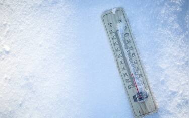 The thermometer on the snow shows low temperatures well below zero. Extreme winter freezing weather.