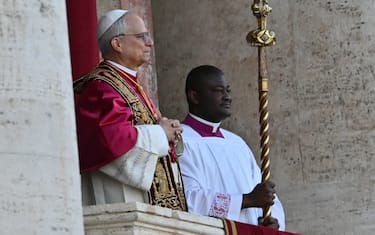 Newly elected Pope Robert Francis Prevost, Pope Leo XIV, (L) arrives on the main central loggia balcony of the St Peter's Basilica for the first time, after the cardinals ended the conclave, in The Vatican, on May 8, 2025. Robert Francis Prevost was on Thursday elected the first pope from the United States, the Vatican announced. A moderate who was close to Pope Francis and spent years as a missionary in Peru, he becomes the Catholic Church's 267th pontiff, taking the papal name Leo XIV. (Photo by Andrej ISAKOVIC / AFP)