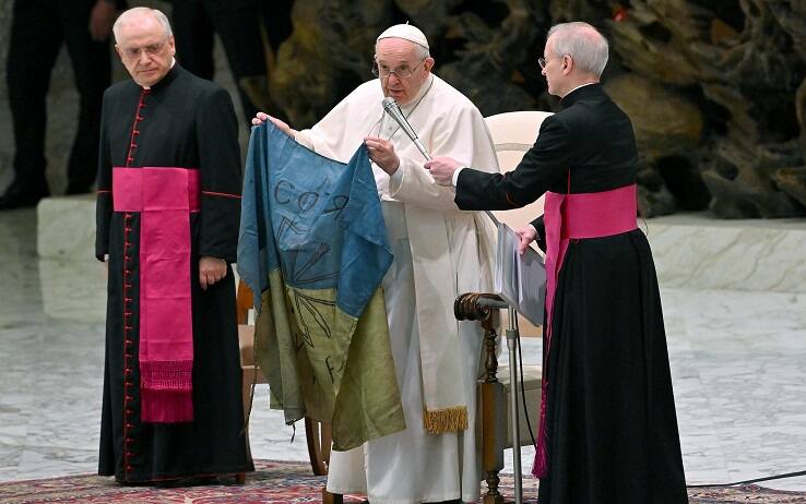 Pope Francis shows a flag of Ukraine that comes from the city of Bucha during the weekly general audience in Paolo VI Hall, Vatican City, 06 April 2022.  ANSA/ETTORE FERRARI 