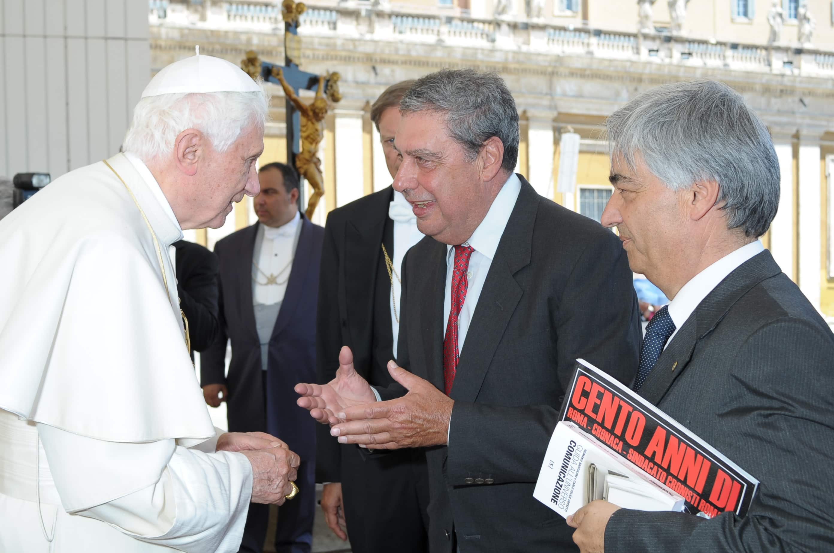 Il Santo Padre Benedetto XVI con Romano Bartoloni e Carlo Felice Corsetti oggi 22 giugno in Vaticano. Papa Wojtyla patrono dei comunicatori nell'era digitale, questo è l'appello che il presidente del Sindacato cronisti romani, Romano Bartoloni, ha rivolto a Benedetto XVI consegnandogli una medaglia d'oro coniata nel centenario (1910-2010) dell'associazione. L'incontro con il Papa è avvenuto nel corso dell'udienza generale in piazza San Pietro. Benedetto XVI ha salutato con particolari parole di incoraggiamento la rappresentanza dei cronisti presente nella piazza. Il Sindacato cronisti romani spera che Karol Wojtyla, in coincidenza con la sua attesissima canonizzazione, possa venire proclamato patrono di tutti i comunicatori in riconoscimento "della sua saggia e coraggiosa apertura alle nuove tecnologie". I giornalisti hanno come loro patrono san Francesco di Sales.    ANSA/OSSERVATORE ROMANO

