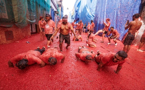 epa13192498 People battle with overripe tomatoes during the traditional 'Tomatina' fiesta in Bunol, Valencia, Spain, 26 August 2026. Thousands of people attend the annual event, where overripe tomatoes are thrown during the traditional tomato fight.  EPA/BIEL ALINO
