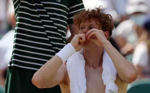 Italy's Jannik Sinner eats during a break of his men's singles quarter-final tennis match against Germany's Jan-Lennard Struff on the ninth day of the 2026 Wimbledon Championships at The All England Lawn Tennis and Croquet Club in Wimbledon, southwest London, on July 7, 2026. (Photo by Adrian Dennis / AFP) / RESTRICTED TO EDITORIAL USE