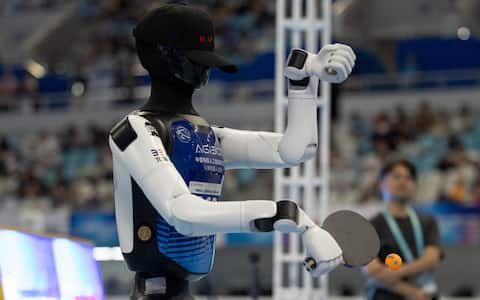 epa13186082 A humanoid robot takes part in the table tennis event during the 2026 World Humanoid Robot Games at the National Speed Skating Oval in Beijing, China, 23 August, 2026. The 2026 World Humanoid Robot Games are being held in Beijing until 26 August.  EPA/ANDRES MARTINEZ CASARES