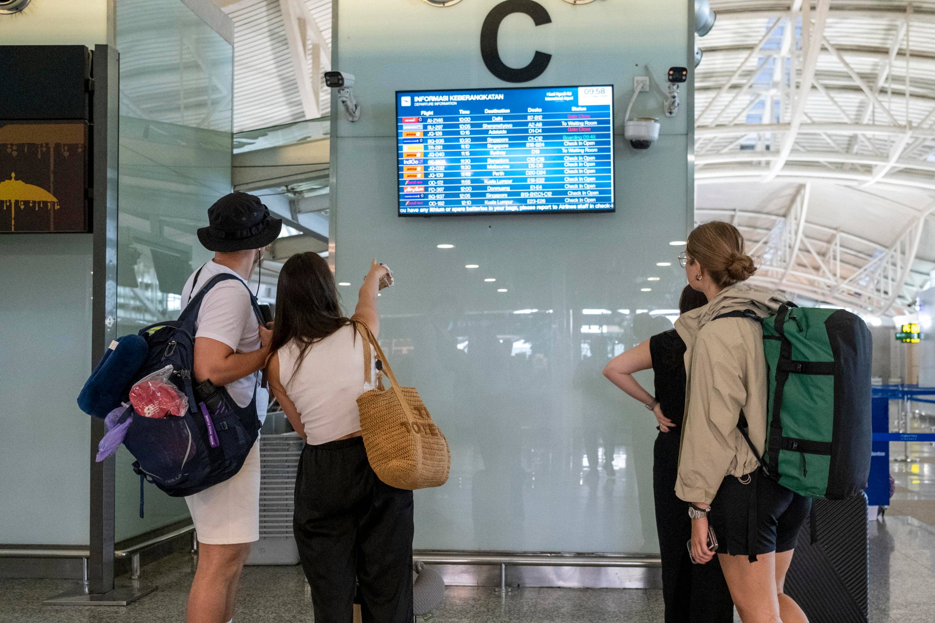 epa12786256 Passengers look at flight information at Ngurah Rai International Airport in Bali, Indonesia, 01 March 2026. At least four flights from Bali to Doha and Dubai have been canceled amid US and Israeli strikes on Iran.  EPA/MADE NAGI