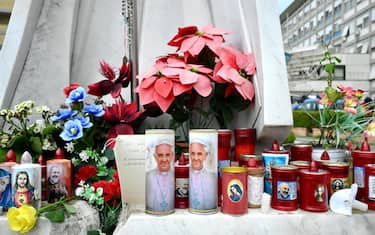 Alcuni lumini posizionati sotto la statua di Giovanni Paolo II all ingresso del Policlinico Gemelli, dove è ricoverato Papa Francesco, Roma, 19 febbraio 2025. ANSA/ALESSANDRO DI MEO