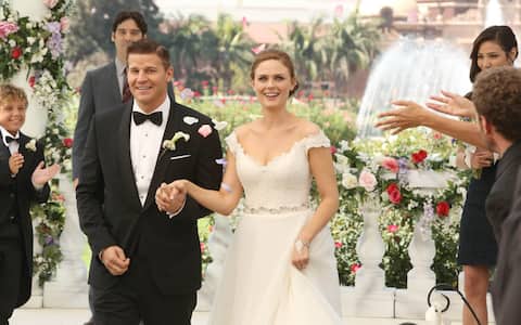 BONES:  Brennan (Emily Deschanel, R) and Booth (David Boreanaz, L) at their wedding in the "The Woman in White" episode of BONES airing Monday, Oct. 21 (8:00-9:00 PM ET/PT) on FOX.  Also pictured background L-R: guest star Ty Panitz, guest star Mather Zickel and Michaela Conlin.  ©2013 Fox Broadcasting Co.  Cr:  Patrick McElhenney/FOX