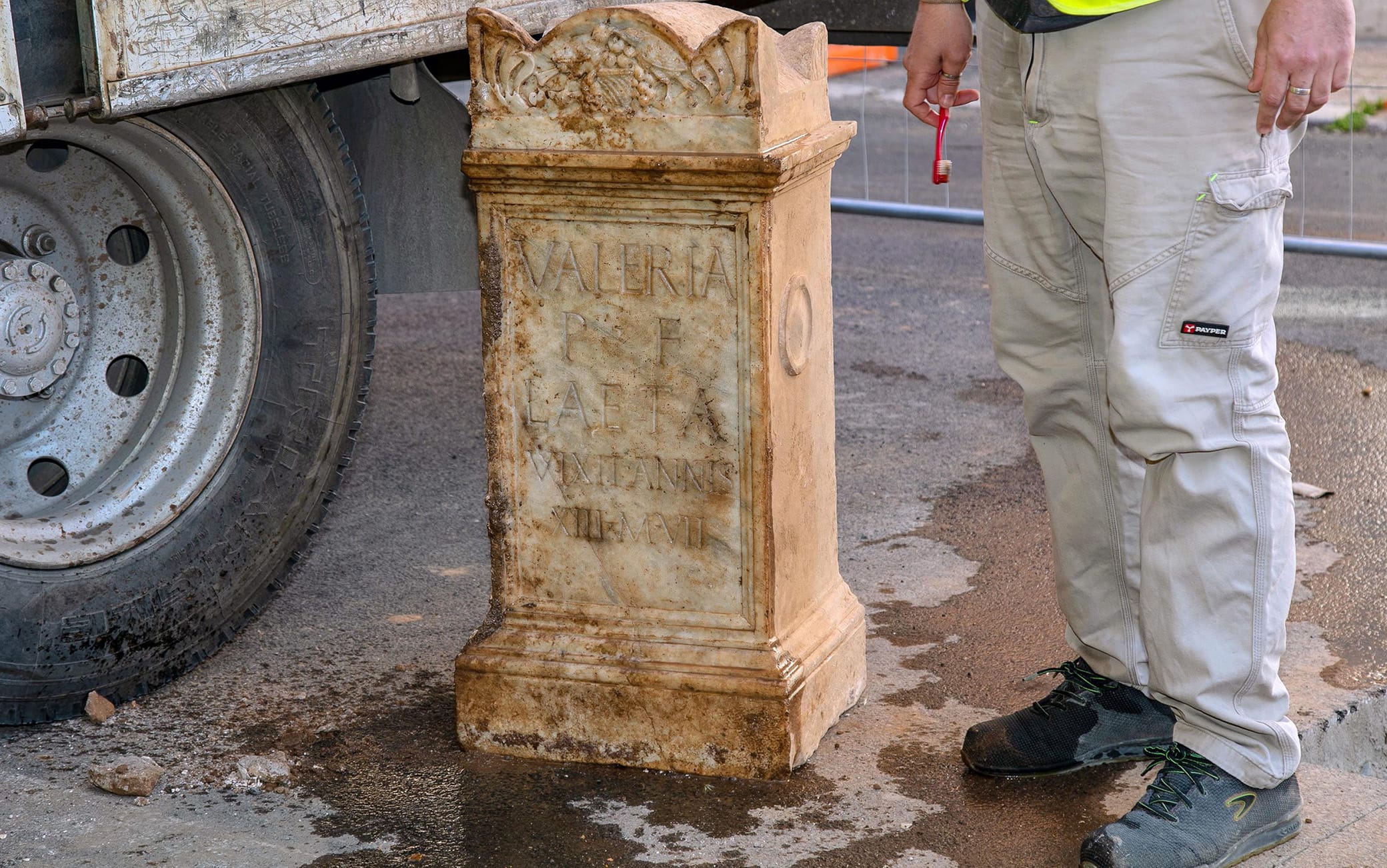 Un'ara in marmo bianco, perfettamente conservata, con la storia di una giovinetta romana, Valeria, morta poco più che bambina a 13 anni e 7 mesi. Ma anche frammenti preziosi di un sarcofago a vasca in marmo decorato con raffinate scene di caccia, che si pensa risalire al II secolo d.C.Arrivano da uno scavo in via Luigi Tosti, legato ai lavori propedeutici alla bonifica idrica della strada svolta da Acea Ato2, le nuove scoperte della Soprintendenza Speciale di Roma diretta da Daniela Porro. Lo scavo condotto da Archeo di Fabio Turchetta con la direzione scientifica di Angelina De Laurenzi, ha portato alla luce un edificio funerario che faceva parte della necropoli dell'antica via Latina con olle, urne cinerarie murate nelle pareti , sepolture a inumazione e resti in marmo di grande interesse. L'ara della giovanissima Valeria è stata trovata a due metri sotto all'attuale piano stradale. Sull'epigrafe si legge la dedica: «Valeria P F Laeta vixit annis XIII m VII». La scritta, in capitale latina, secondo le prime ipotesi di studio potrebbe essere sciolta con la frase: «Valeria Laeta figlia di P[ublio] visse 13 anni e 7 mesi». Suggestiva anche la scoperta dei frammenti del sarcofago a lenòs - ovvero a vasca con gli angoli stondati - in marmo bianco. La decorazione a bassorilievo di uno dei pezzi presenta scene di caccia con una leonessa sovrastata a sinistra dal cavallo del cacciatore (di cui si conservano esclusivamente le zampe anteriori) e braccata sulla destra da un mastino. Il colombario di piccole dimensioni, 4 metri per 3, probabilmente ipogeo, era realizzato nel banco naturale di tufo e costituito da possenti murature in opera cementizia di 80 centimetri ricoperte da un paramento in mattoni, opus latericium, di ottima fattura. Le pareti erano rivestite di intonaco dipinto di giallo e rosso, a emulare delle lastre marmoree. L'edificio è stato rinvenuto però fortemente danneggiato, tanto che non si può escludere, spiegano gli archeologi, che possa essere 