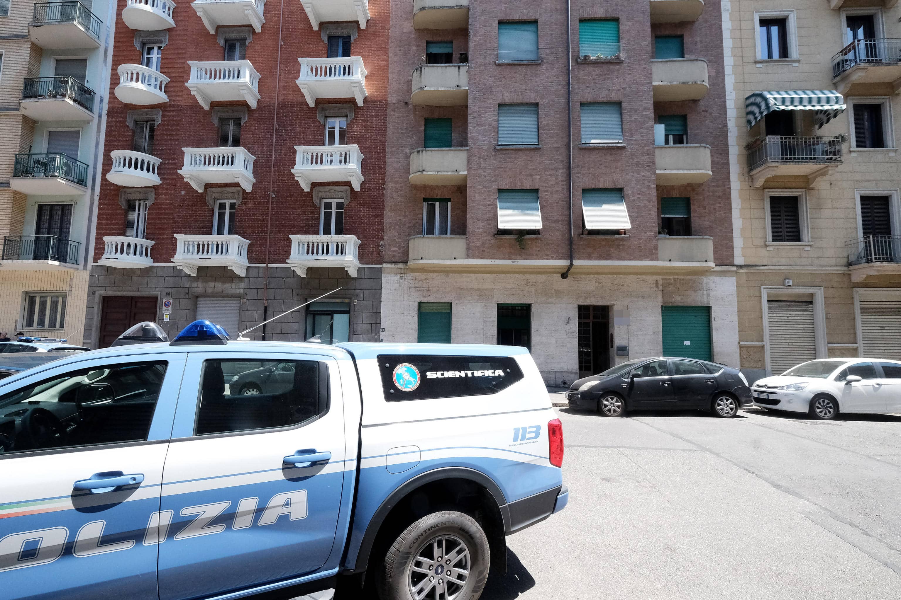 Agenti di polizia all'esterno della palazzina dove una donna e la figlia sono state trovate morte, in via Domodossola, a Torino, 21 giugno 2026.                                           ANSA/ ALESSANDRO DI MARCO