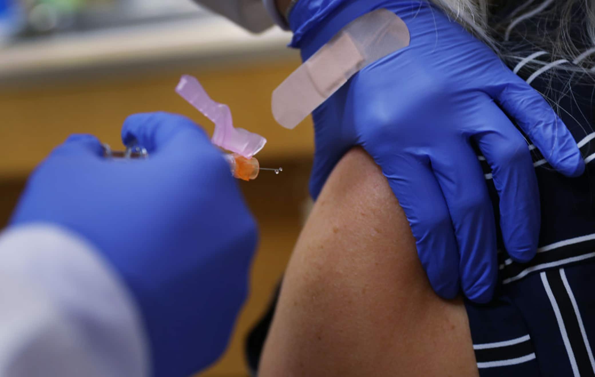KEY BISCAYNE, FLORIDA - SEPTEMBER 03: Enbal Sabag, a Nurse Practitioner, wears personal protection equipment as she administers a flu vaccination to Noel Janzen at the CVS pharmacy and MinuteClinic on September 03, 2020 in Key Biscayne, Florida. Flu shots are available at the nearly 10,000 CVS pharmacies and approximately 100 MinuteClinic locations across the country. Heath experts say getting the flu shot this year is important because the dangers of having COVID-19 and the flu simultaneously are still unknown.  (Photo by Joe Raedle/Getty Images)