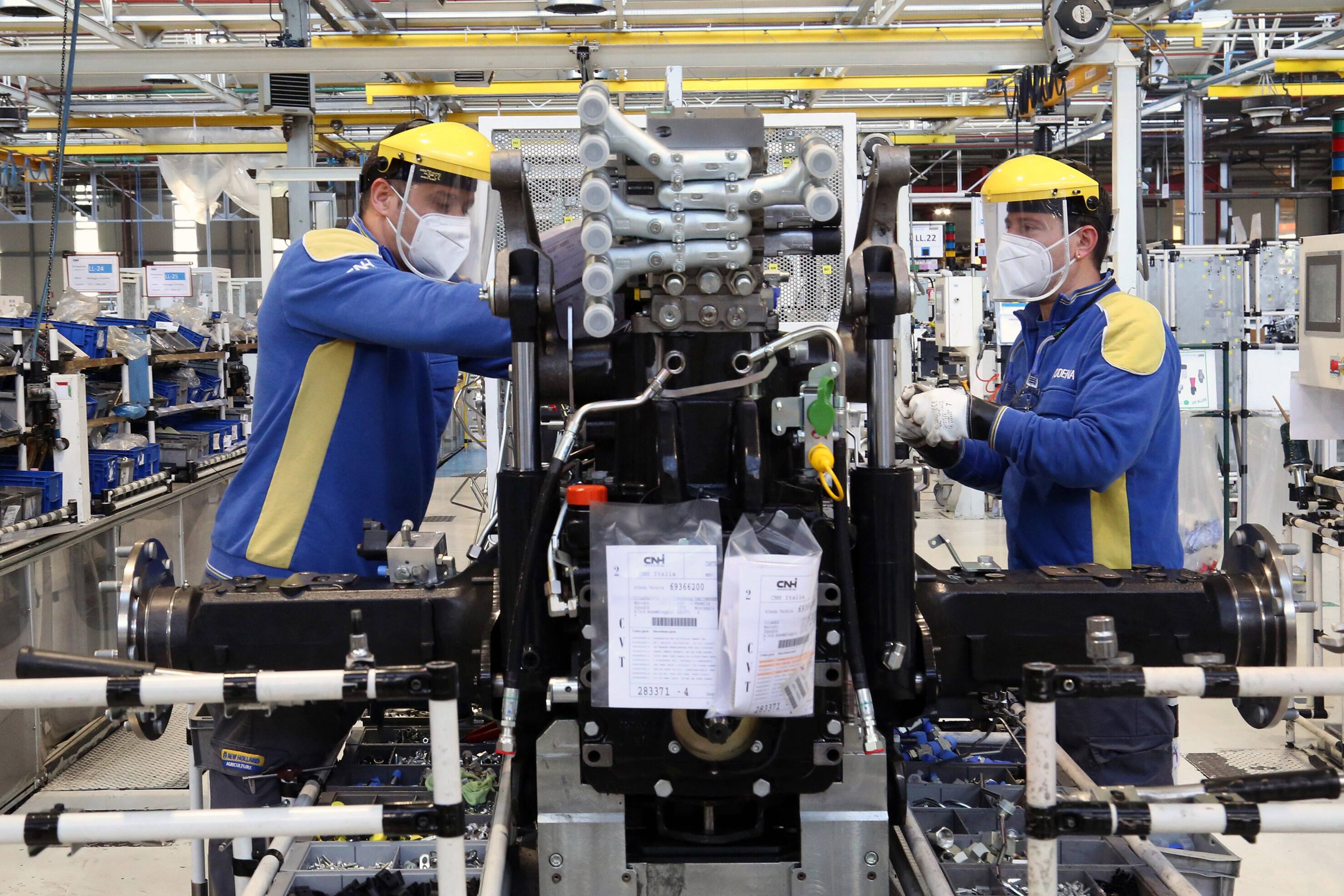Modena. Operai all'interno dello stabilimento New Holland di CNH Industrial al lavoro sulla linea di assemblaggio del gruppo trasmissione dei trattori indossano la mascherina e la visiera contro il Coronavirus (ROBERTO BRANCOLINI/Fotogramma, Modena - 2020-04-29) p.s. la foto e' utilizzabile nel rispetto del contesto in cui e' stata scattata, e senza intento diffamatorio del decoro delle persone rappresentate