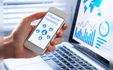 Inlfuencer marketing concept on a mobile phone screen with a diagram showing a social network advertising strategy with communication to people