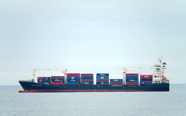 Container cargo ship, profile view, transport of shipping goods. Genova Italy - December 2021