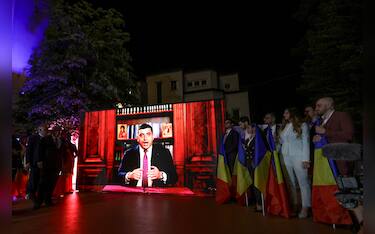 epa12073734 Alliance for the Union of Romanians (AUR) party leader George Simion is displayed delivering a speech on a screen at the AUR party headquarters in Bucharest, Romania, 04 May 2025. According to exit polls, ultra-nationalist party AUR leader George Simion is projected to qualify for the presidential runoff on 18 May.  EPA/ROBERT GHEMENT