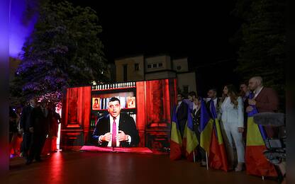 epa12073734 Alliance for the Union of Romanians (AUR) party leader George Simion is displayed delivering a speech on a screen at the AUR party headquarters in Bucharest, Romania, 04 May 2025. According to exit polls, ultra-nationalist party AUR leader George Simion is projected to qualify for the presidential runoff on 18 May.  EPA/ROBERT GHEMENT