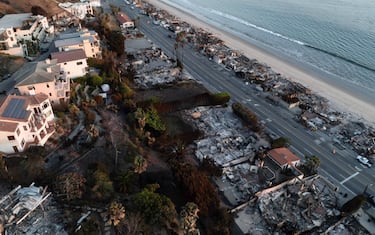 epa11827702 A photo taken by a drone shows an aerial view of a neighborhood destroyed by the Palisades wildfire in Malibu, California, USA, 15 January 2025. Multiple wildfires, which have already destroyed thousands of homes and forced the evacuation of numerous neighborhoods, continue to burn across thousands of acres in Southern California, including the Los Angeles area.  EPA/TED SOQUI