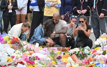 epa12595447 Mourners react after placing flowers at a makeshift memorial at Bondi Beach in Sydney, Australia, 16 December 2025. Australia is in mourning following an attack on the Jewish community's Hanukkah festival celebrations on 14 December that left at least 16 people dead, including one gunman.  EPA/MICK TSIKAS AUSTRALIA AND NEW ZEALAND OUT