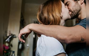 A couple affectionately kissing each other after matching on a dating app online.