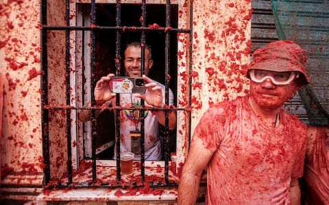 epa13192500 People battle with overripe tomatoes during the traditional 'Tomatina' fiesta in Bunol, Valencia, Spain, 26 August 2026. Thousands of people attend the annual event, where overripe tomatoes are thrown during the traditional tomato fight.  EPA/BIEL ALINO