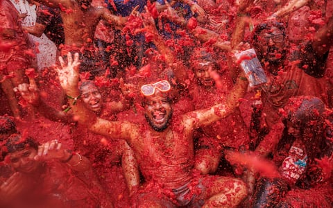 epa13192501 People battle with overripe tomatoes during the traditional 'Tomatina' fiesta in Bunol, Valencia, Spain, 26 August 2026. Thousands of people attend the annual event, where overripe tomatoes are thrown during the traditional tomato fight.  EPA/BIEL ALINO