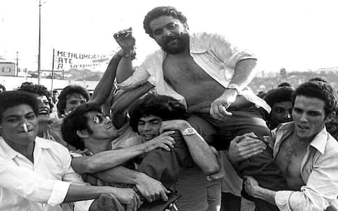 (FILES) This 22 March 1979 file photo shows Luiz Inacio Lula da Silva being lifted by metalworker colleagues after a union rally in Sao Bernardo do Campo, 55kms from Sao Paulo. Da Silva, presidential candidate for the Workers' Party, has been declared the winner of the presidential election run-off 27 October, 2002.  AFP PHOTO/CLAUDINEI PETROLI-AESTADO/FILES/BRAZIL OUT - INTERNET OUT (Photo credit should read CLAUDINEI PETROLI/AFP via Getty Images)